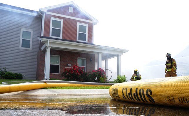 Firefighters from the 509th Civil Engineer Squadron practice entering a simulated burning house during an exercise at Whiteman Air Force Base, Mo., June 7, 2013. The fire services mission is to prevent fires; minimize injuries and loss of lives; protect property and the environment during periods of peace, war, military operations other than war; and provide humanitarian support operations for those charged in their care. (U.S. Air Force photo by Airman 1st Class Bryan Crane/Released)
