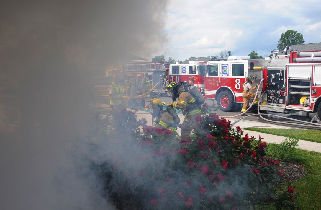 Firefighters from the 509th Civil Engineer Squadron battle a mock fire in base housing at Whiteman Air Force Base, Mo., June 7, 2013. Airmen from Whiteman AFB Fire Emergency Services work in two separate 24-hour shifts to keep the station manned and mission-ready 24/7. (U.S. Air Force photo by Airman 1st Class Bryan Crane/Released)