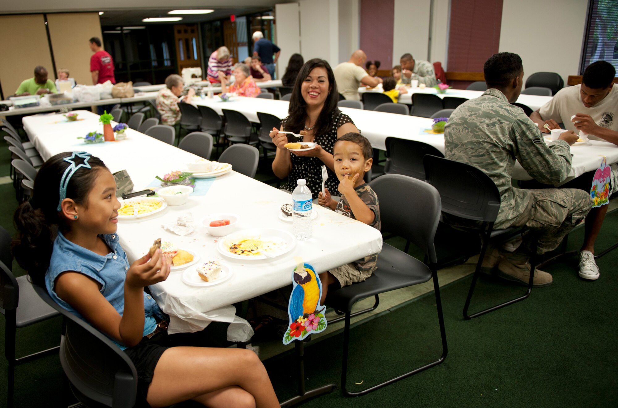 The family of Master Sgt.  Phannak Srun, 1st Special Operations Maintenance Squadron NCO in charge of systems, enjoys a meal white waiting for alterations on a uniform during the Munch and Mend in the chapel cafeteria on Hurlburt Field, Fla., June 10, 2013. Munch and Mend is designed for any Hurlburt personnel regardless of religious preference. (U.S. Air Force photo by Senior Airman Krysatl M. Garrett) 