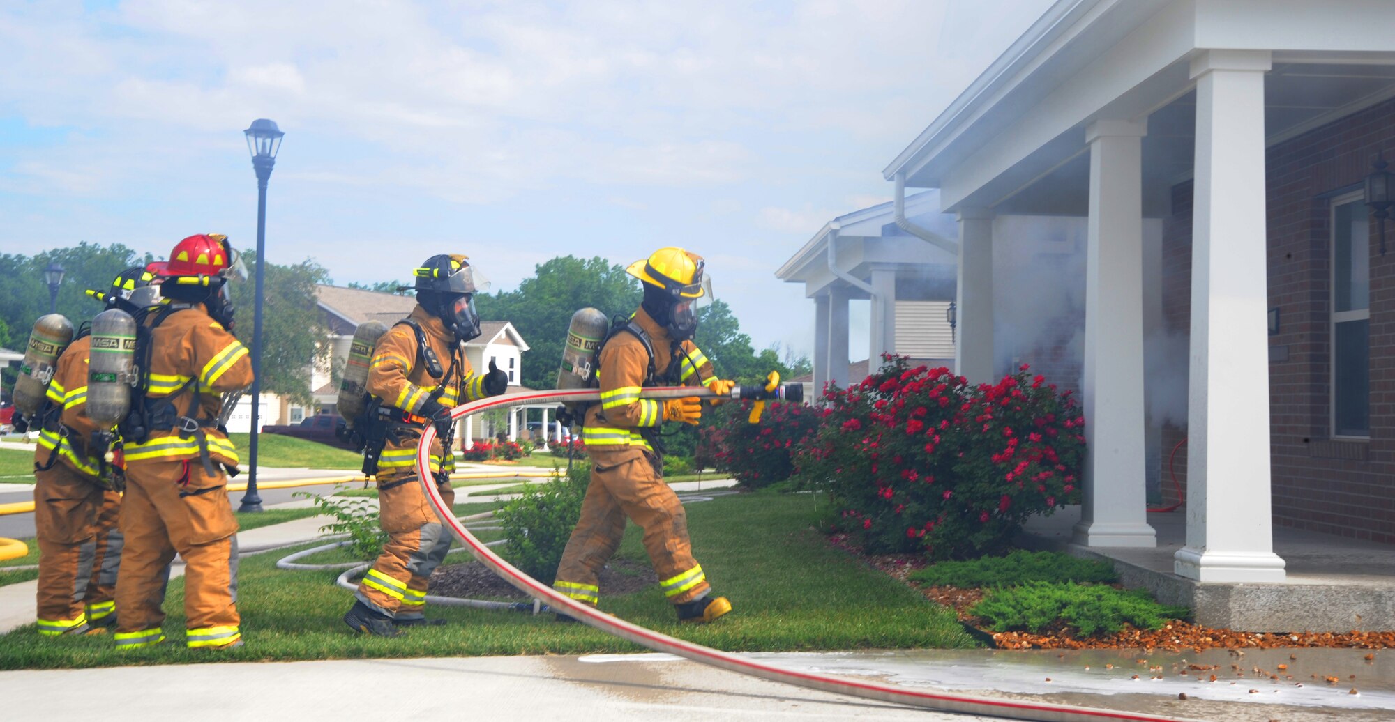 Firefighters from the 509th Civil Engineer Squadron prepare to enter a house during a fire training exercise at Whiteman Air Force Base, Mo., June 7, 2013. The fire department was inspected on efficiency and accuracy in responding to a blaze. (U.S. Air Force photo by Airman 1st Class Bryan Crane/Released)