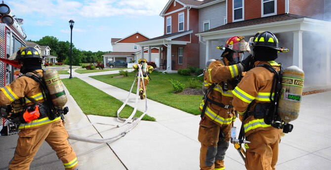 Firefighters from the 509th Civil Engineer Squadron rush to the scene of a mock fire at Whiteman Air Force Base, Mo., June 7, 2013. The fire fighters had to show how well they could work together to rescue a mock victim from a burning house. (U.S. Air Force photo by Airman 1st Class Bryan Crane/Released)