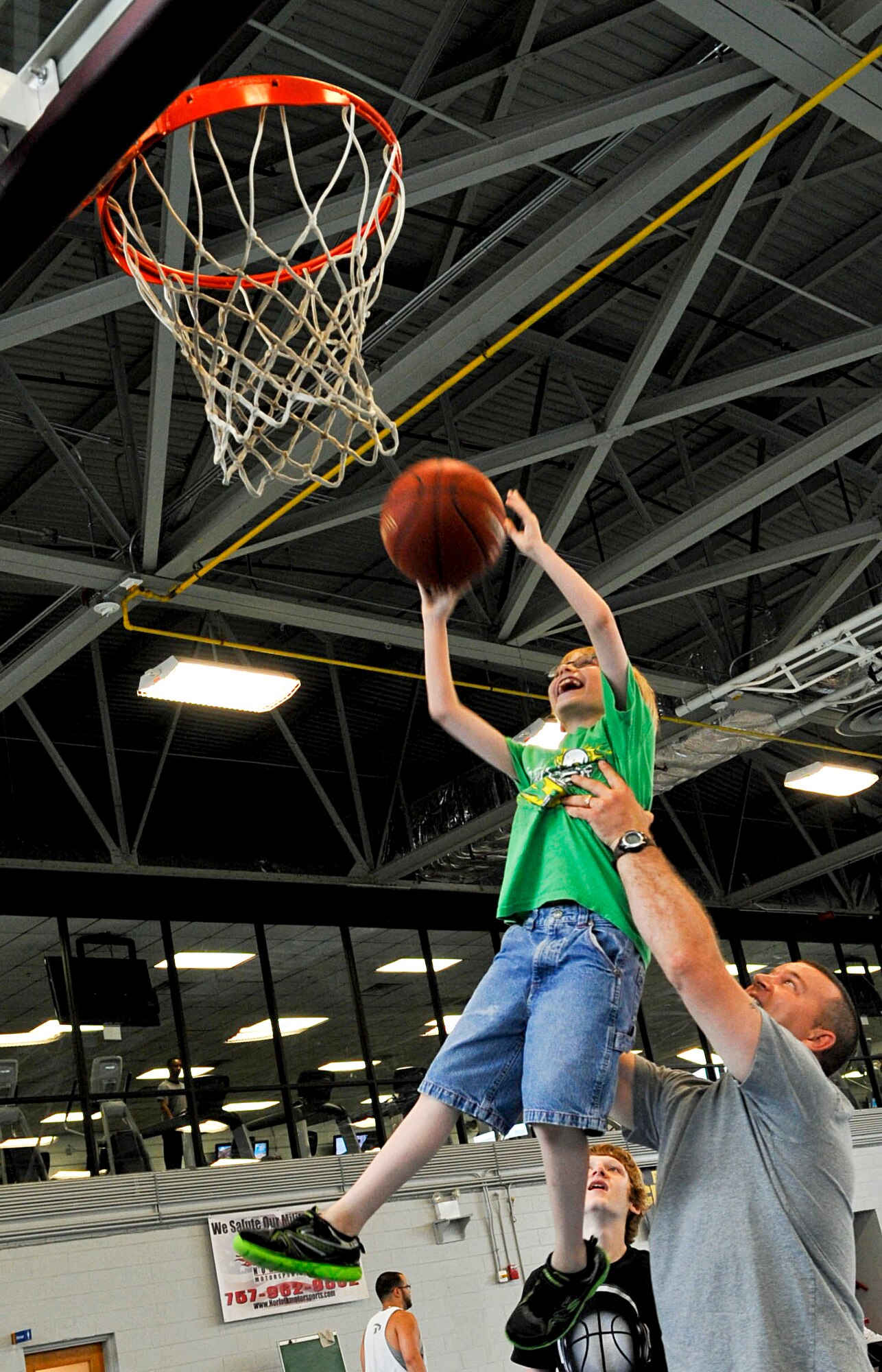 U.S. Army Staff Sgt. Matthew Ducote, 221st Military Police Detachment patrol platoon sergeant, lifts his son Trystan into the air to score during a basketball game at Anderson Field House on Fort Eustis, Va., June 10. Ducote spends his off-duty time playing games and fishing with his children and family. (U.S. Air Force photo by Staff Sgt. Wesley Farnsworth/Released)