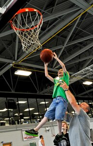 U.S. Army Staff Sgt. Matthew Ducote, 221st Military Police Detachment patrol platoon sergeant, lifts his son Trystan into the air to score during a basketball game at Anderson Field House on Fort Eustis, Va., June 10. Ducote spends his off-duty time playing games and fishing with his children and family. (U.S. Air Force photo by Staff Sgt. Wesley Farnsworth/Released)