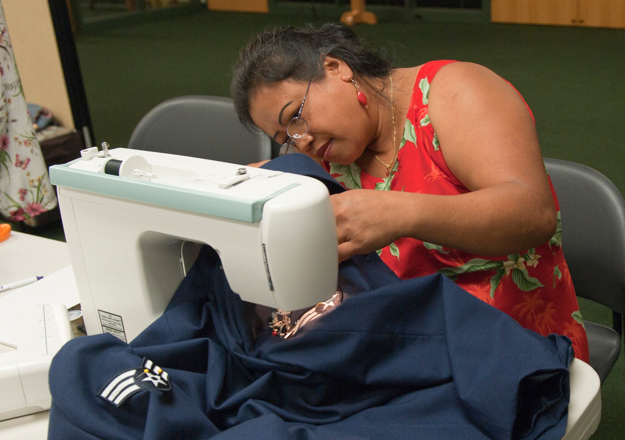 Tssie Porter, a Munch and Mend volunteer, sews stripes onto a U.S. Air Force service coat during the Munch and Mend program in the chapel cafeteria on Hurlburt Field, Fla., June 10, 2013. Munch and Mend has provided for Hurlburt personnel for almost two decades.(U.S. Air Force photo by Senior Airman Krystal M. Garrett)