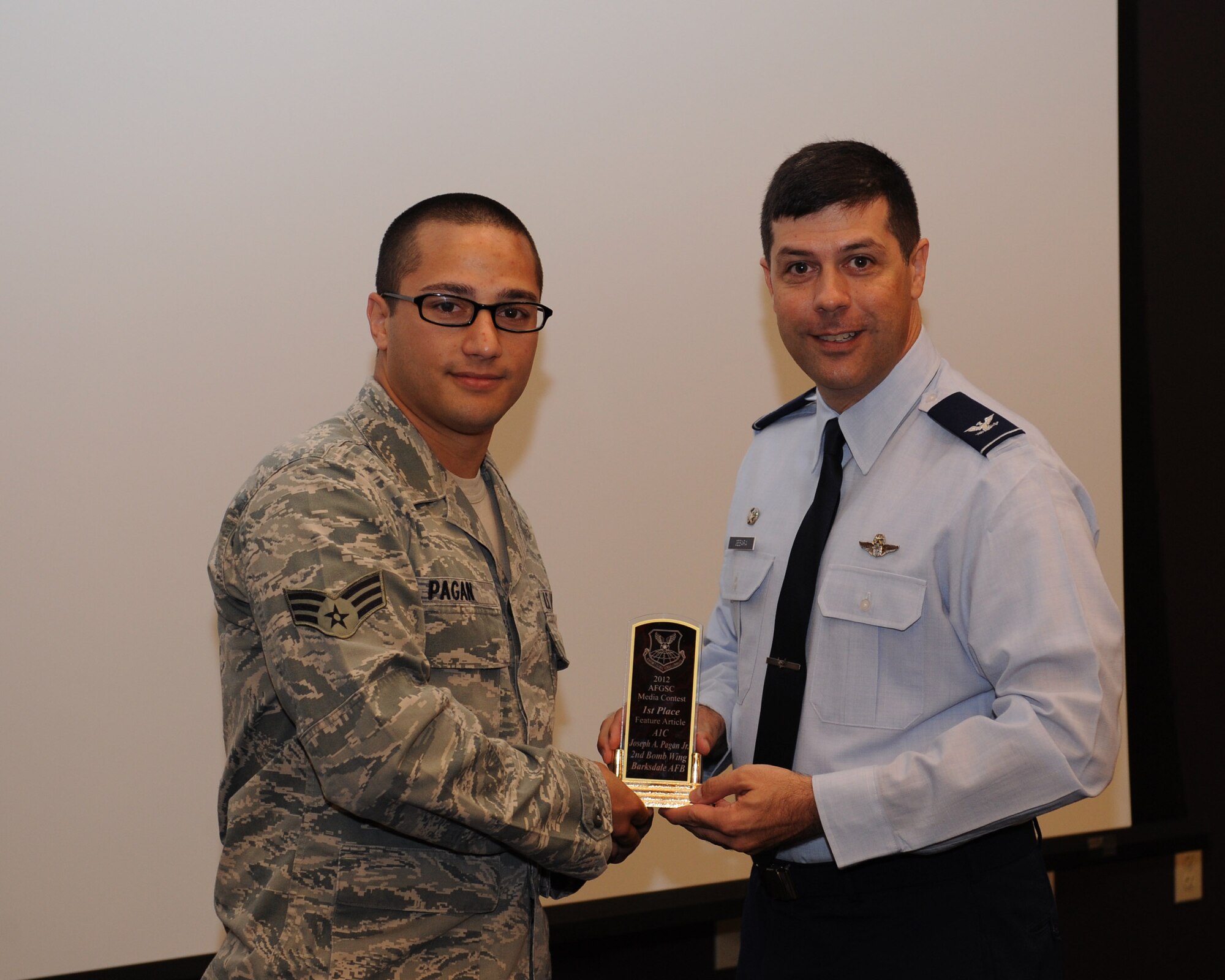 Senior Airman Joseph Pagan, Air Force Global Strike Command Public Affairs photojournalist, receives the 2012 Air Force Global Strike Command Media Award for best feature article from Col. Andrew Gebara, 2nd Bomb Wing commander, on Barksdale Air Force Base, La., June 12, 2013. (U.S. Air Force photo/Airman 1st Class Benjamin Gonsier)
