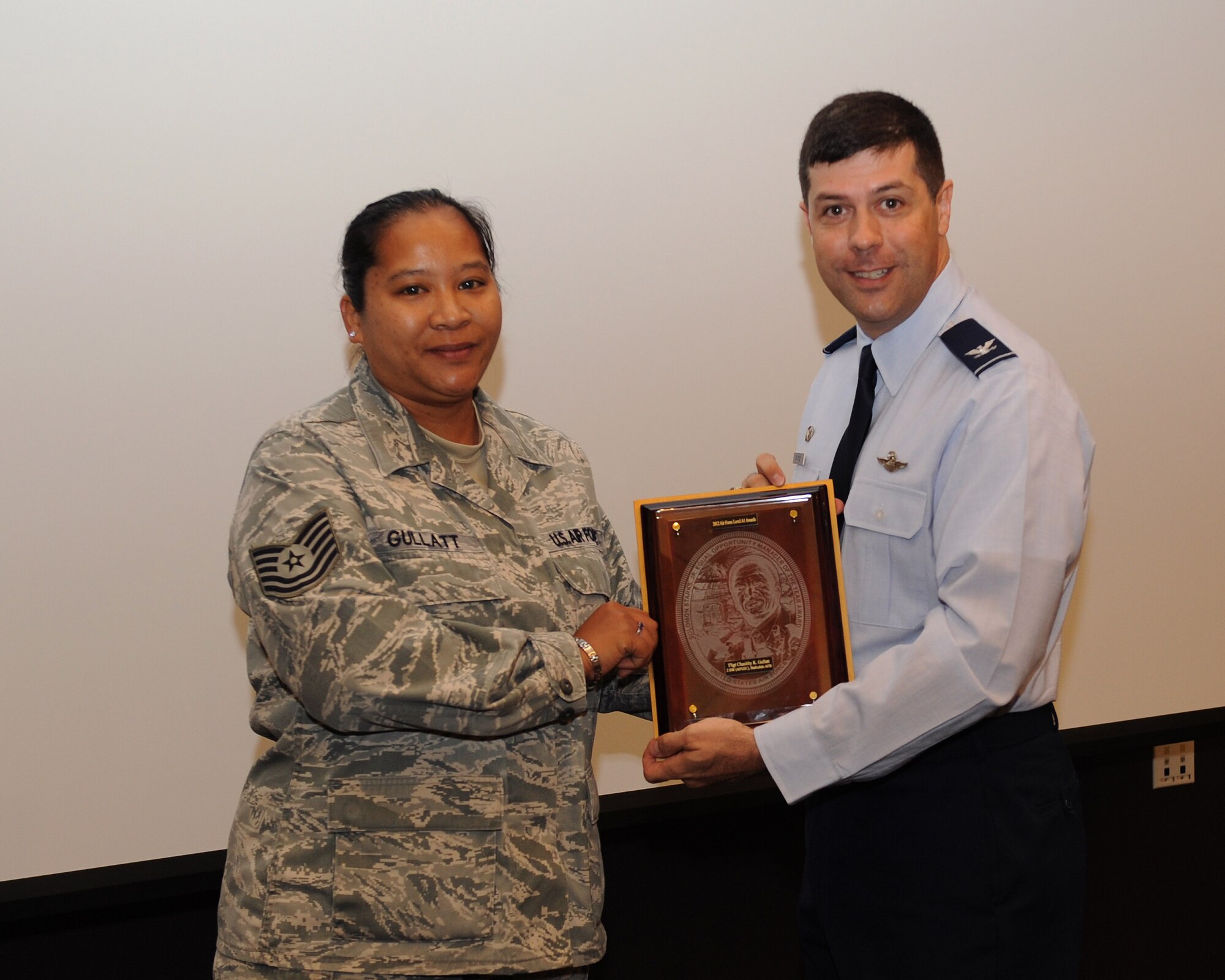 Tech. Sgt. Chasitity Gullatt, 2nd Bomb Wing Equal Opportunity Office, receives the 2012 EO Manager of the Year award from Col. Andrew Gebara, 2nd BW commander, on Barksdale Air Force Base, La., June 12, 2013. (U.S. Air Force photo/Airman 1st Class Benjamin Gonsier)
