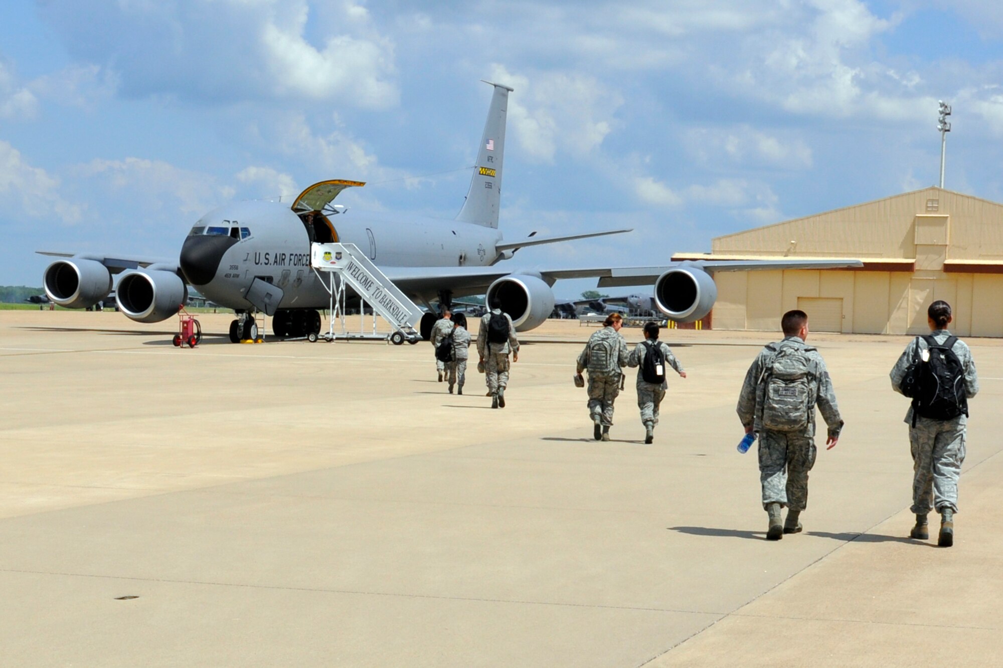 Members of the 307th Force Support Squadron, walk across the ramp to a waiting KC-135 Stratotanker at Barksdale Air Force Base, La., June 7, 2013. The jet, which is assigned to the 459th Air Refueling Wing from Joint Base Andrews, Md., transported 12 Airmen to Dobbins Air Force Base, Ga., where they will receive Force Support Combat Training (FSCT) that prepares them for deployment to austere, bare base locations with limited or no facilities. Then, they will be able transition the area for sustained operations. Services Airmen must regularly complete Home Station Readiness Training (HSRT) and FSCT to stay abreast of changing situations. Services (Prime RIBS) support includes the core functions (life sustaining) of food service, lodging, mortuary (search and recovery, shipment, and/or temporary interment), and laundry. Additional Services functions are; fitness, recreation, non-appropriated funds instrumentality (NAFI), Services supply and administration, learning resource center operations, and protocol. (U.S. Air Force photo by Betty Stephens/Released)