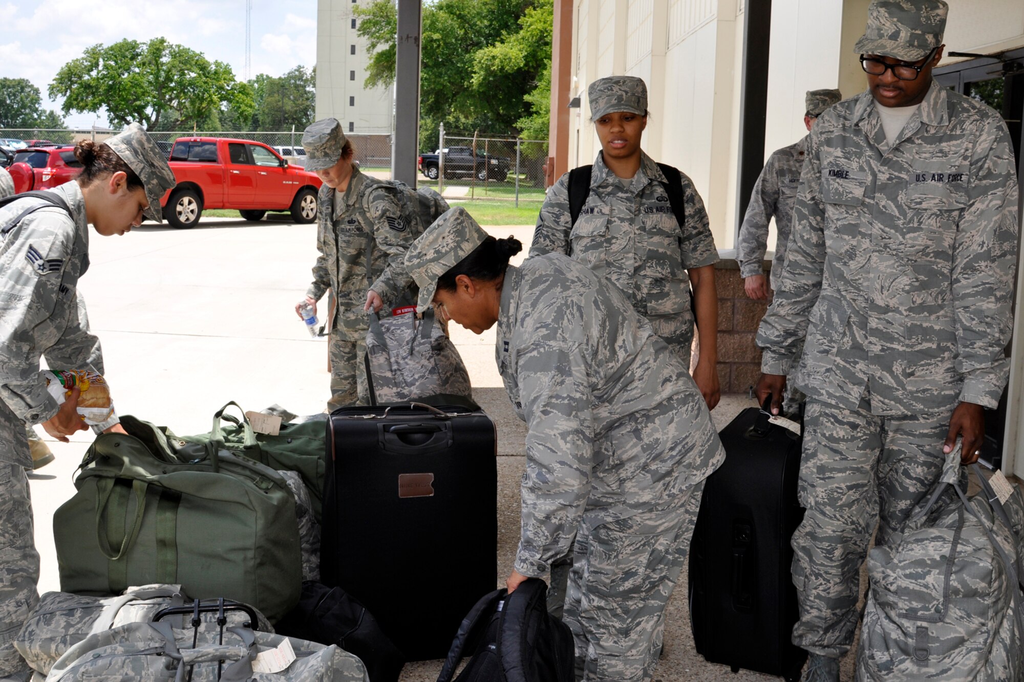 Members of the 307th Force Support Squadron move their bags in preparation for loading onto a KC-135 Stratotanker at Barksdale Air Force Base, La., June 7, 2013. A group of 12 Airmen from the 307 FSS (Services) deployed to Dobbins Air Force Base, Ga., where they will receive Force Support Combat Training (FSCT) preparing them for deployment to austere, bare base locations with limited or no facilities. With this training they will be able to transition the area for sustained operations. Services Airmen must regularly complete Home Station Readiness Training (HSRT) and FSCT to stay abreast of changing situations. (U.S. Air Force photo by Betty Stephens/Released)
