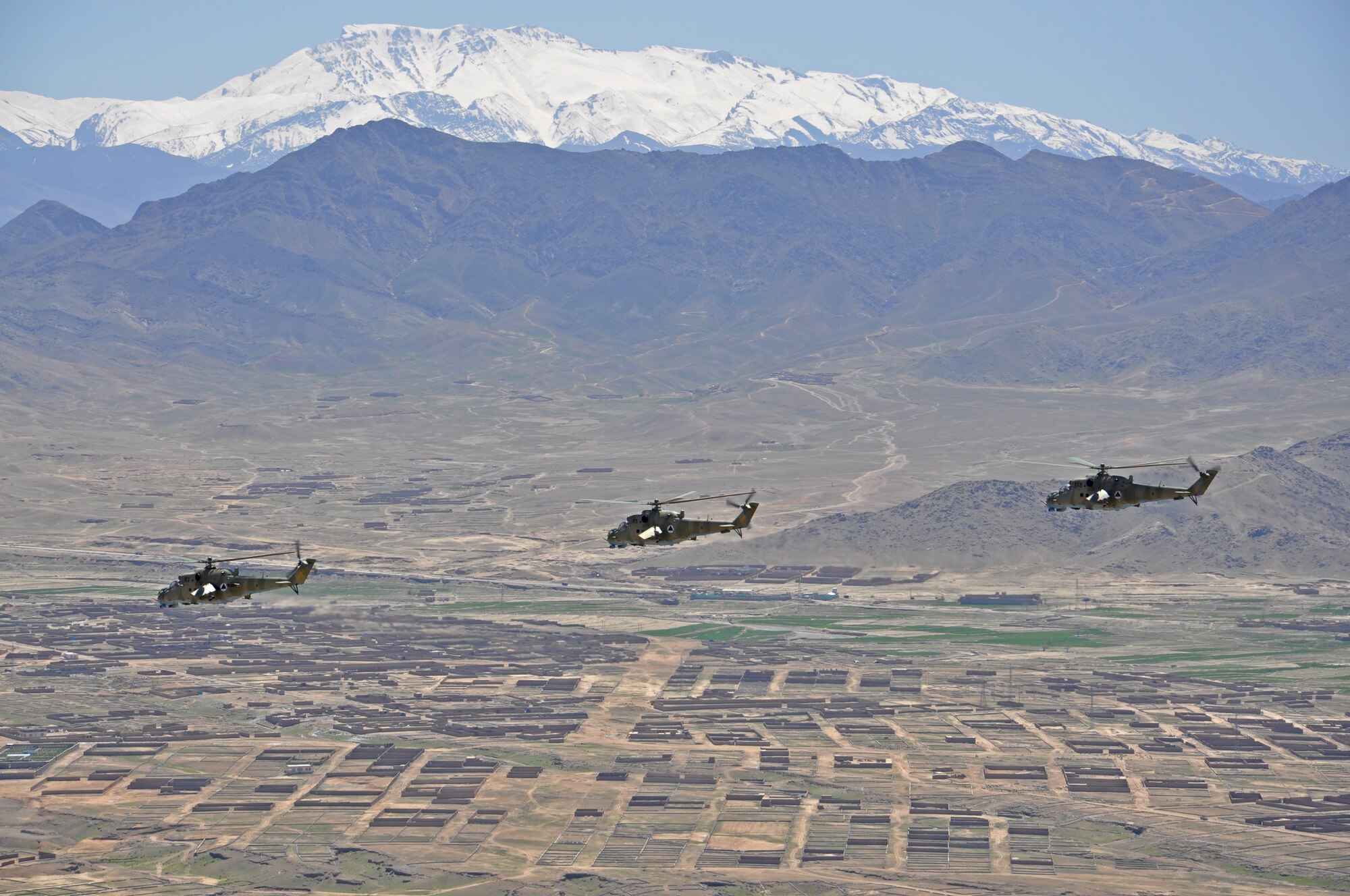 A three ship Mi-35 helicopter formation from the Kabul Air Wing flies as part of a training mission outside of Kabul, Afghanistan. The mission included members of both the Afghan Air Force and NATO Air Training Command-Afghanistan, which trains and advises the AAF. (U.S. Air Force photo/Capt. Anastasia Wasem)