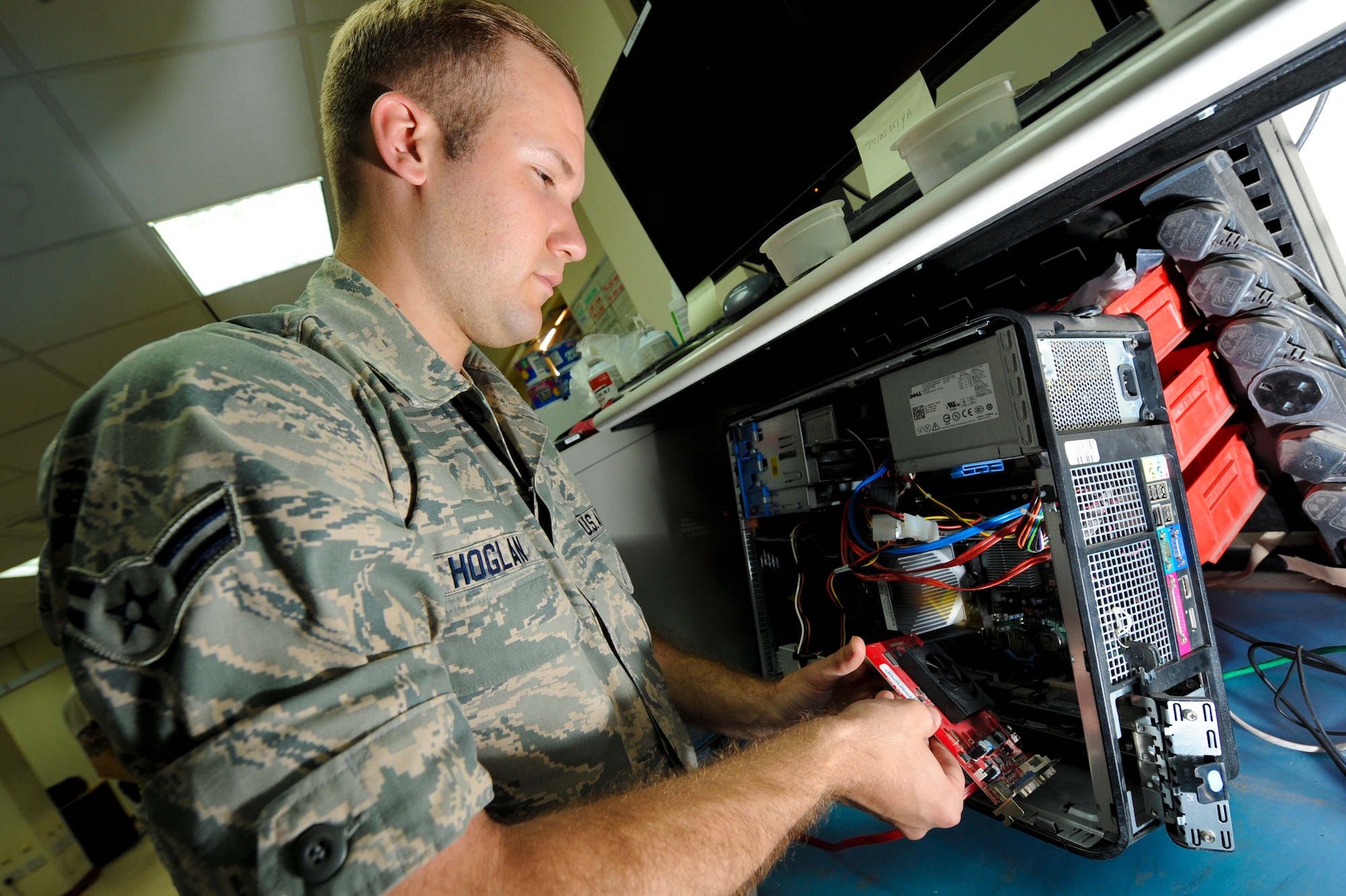 U.S. Air Force Airman 1st Class Braden Hoglan, 380th Expeditionary Communication Squadron small computer repair technician, removes the video card on a computer being serviced at an undisclosed location in Southwest Asia, June 11, 2013. The small computers shop repairs approximately 100 units every month. Hoglan is native to Amesbury, Mass., and is deployed from Ramstein Air Base, Germany. (U.S. Air Force photo by Staff Sgt. Joshua J. Garcia)