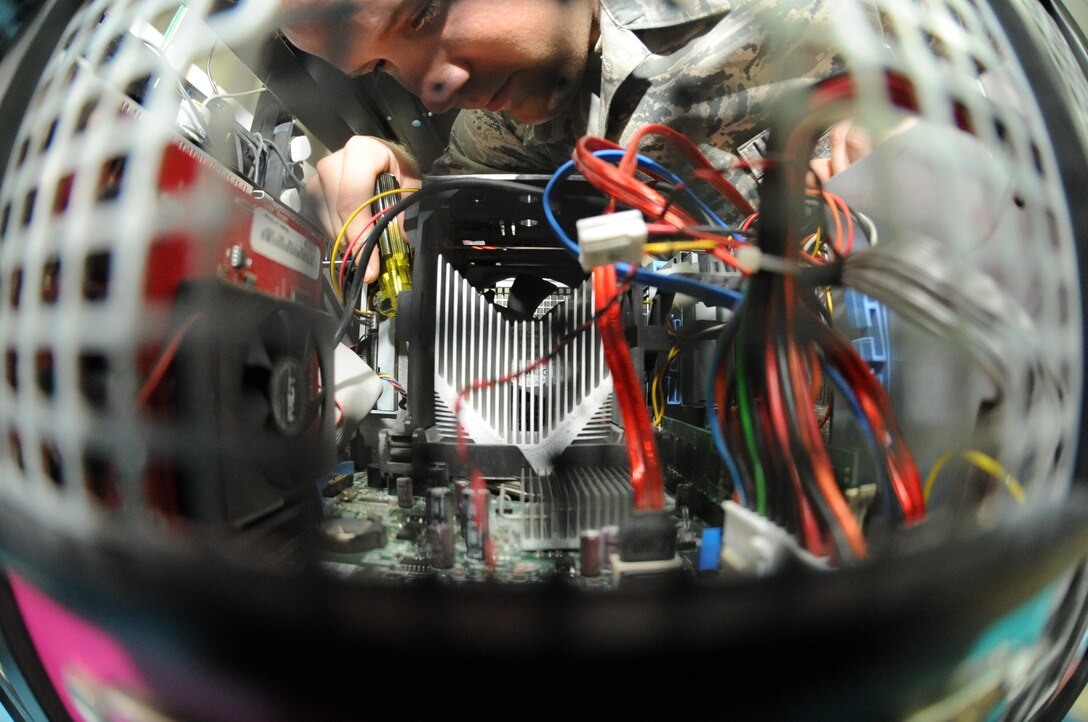 U.S. Air Force Airman 1st Class Braden Hoglan; 380th Expeditionary Communication Squadron small computer repair technician; removes the mother board from a computer unit at an undisclosed location in Southwest Asia June 11; 2013. The small computers shop repairs all computer assets on the installation. Hoglan is native to Amesbury; Mass.; and is deployed from Ramstein Air Base; Germany. (U.S. Air Force photo by Staff Sgt. Joshua J. Garcia)