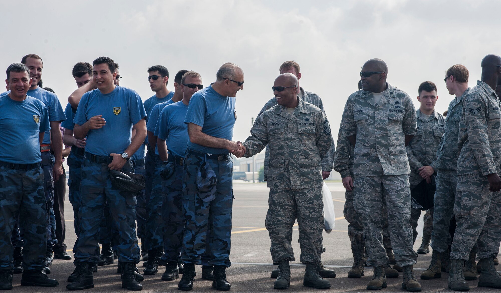Senior Master Sgt. Elvin Young, right-center, 39th Logistics Readiness Squadron, shakes hands with a member of the Turkish air force during a foreign-object-debris walk June 12, 2013, at Incirlik Air Base, Turkey. The FOD walk was a joint task by U.S. and Turkish airmen to ensure the flightline remains safe for incoming and outgoing aircraft. (U.S. Air Force photo by Senior Airman Anthony Sanchelli/Released)