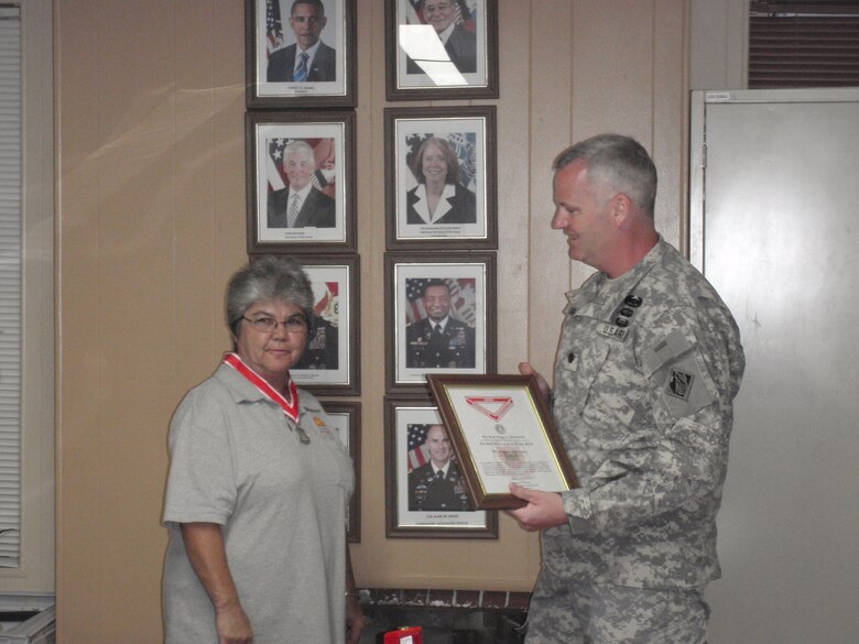 Lt. Col. Thomas Greco, deputy commander for south Florida, awards the Steel de Fleury Medal to retiring lock leader Pam Peralta, the first woman to serve in her position with the Corps in Florida. 