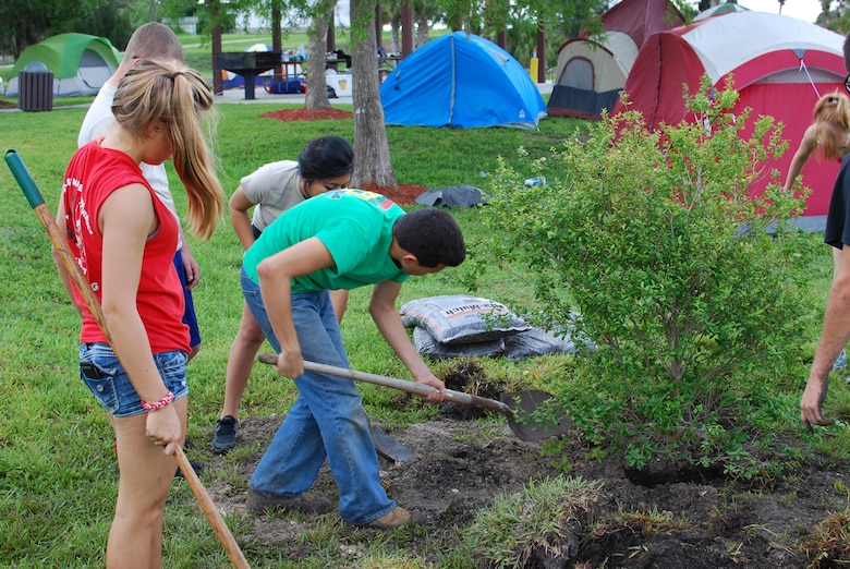 Members of the JROTC unit from North Fort Myers High School plant native shrubs at Ortona North Recreation Area. 