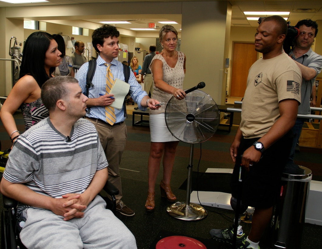 Army Sgt. Ryan Long, far right, shares his prosthetic leg experiences with Boston Marathon bombing victim, J.P. Norden, during Norden's visit to Walter Reed National Military Medical Center in Bethesda, Md., June 12, 2013. Norden and his brother Paul, each lost a leg and were burned and pelted with shrapnel during the second blast while shielding other spectators following the first bomb explosion during the April 15 Boston Marathon bombings. Long said he was on patrol in Afghanistan's Kandahar province last year when the vehicle he was riding in encountered a roadside bomb. With media members listening to his story, Long told Norden, and his girlfriend Kelly Castine, far left, that he's just now getting used to his recently fitted prosthetic leg. DOD photo by Terri Moon Cronk