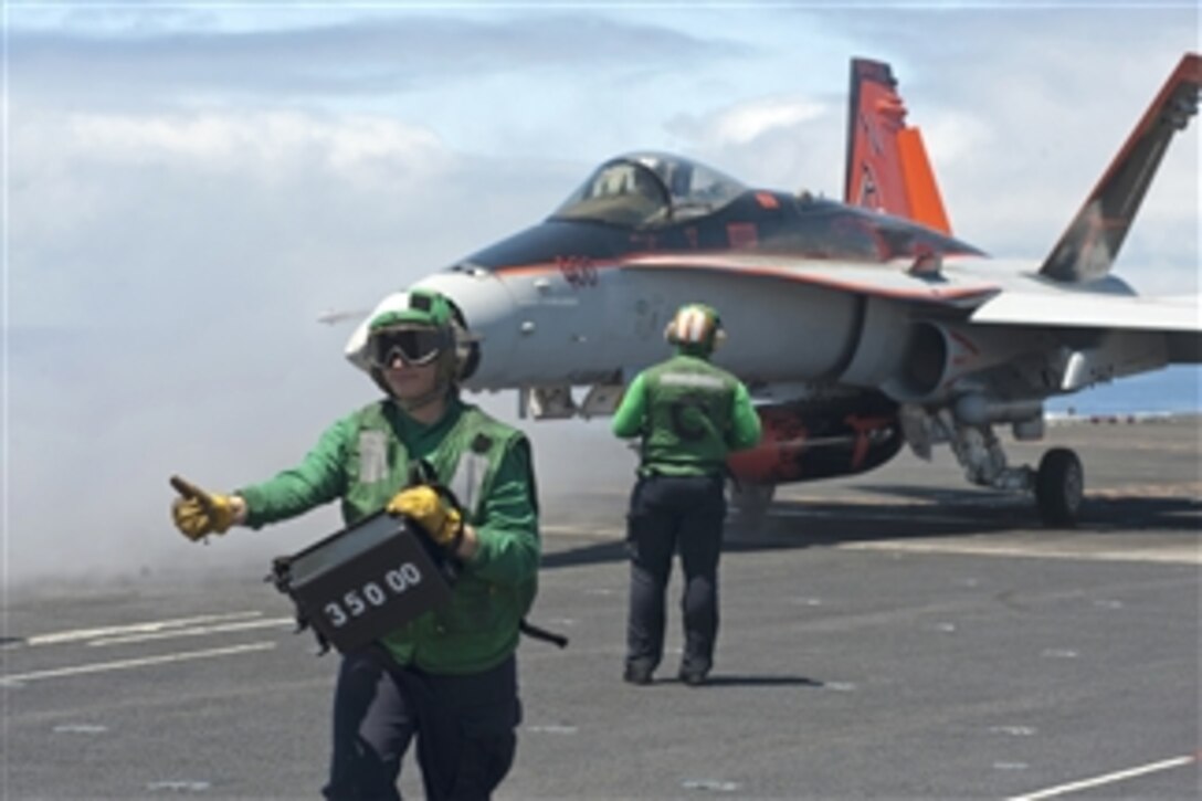 Airman Raven Romero gives the thumbs up as he verifies the weight of an F/A-18C Hornet before launching from the flight deck of the aircraft carrier USS Carl Vinson (CVN 70) during flight operations off the coast of Southern California on June 10, 2013.  Knowing the weight of the aircraft allows the steam catapult operators to adjust the pressure needed for the catapult.  The Hornet is attached to Strike Fighter Squadron 94.  