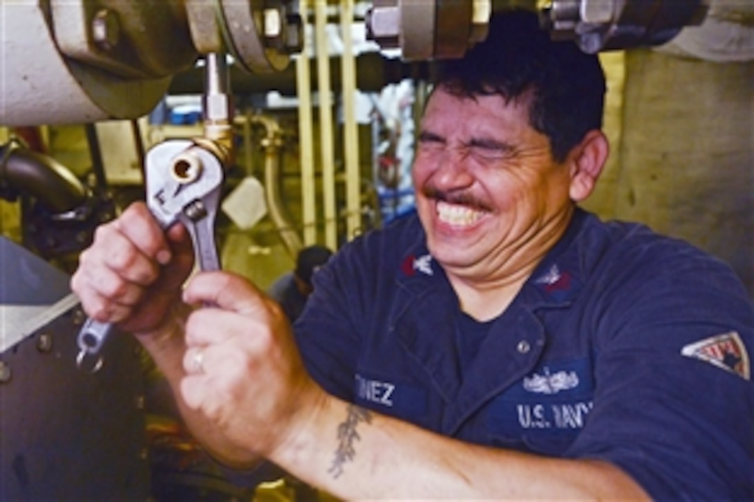 U.S. Navy Petty Officer 1st Class Jaime Martinez tightens a valve aboard the USS Freedom in Singapore, June 6, 2013. The Freedom, the Navy's first littoral combat ship, is currently on it's maiden overseas deployment.