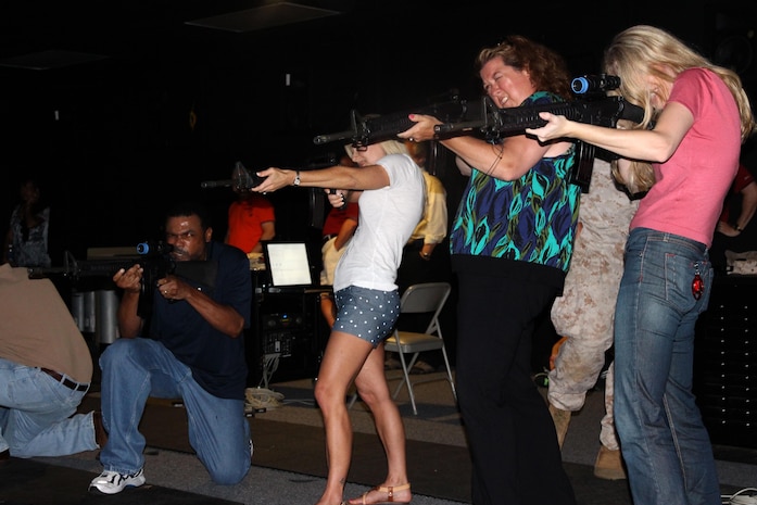 From left: Greg Taylor, Bridget Jukes and Susan Wood of Combat Support Systems are joined by Hallie Balkin, Office of the Counsel, as they take part in a May training exercise at Camp Upshur’s Indoor Simulated Marksmanship Trainer. 