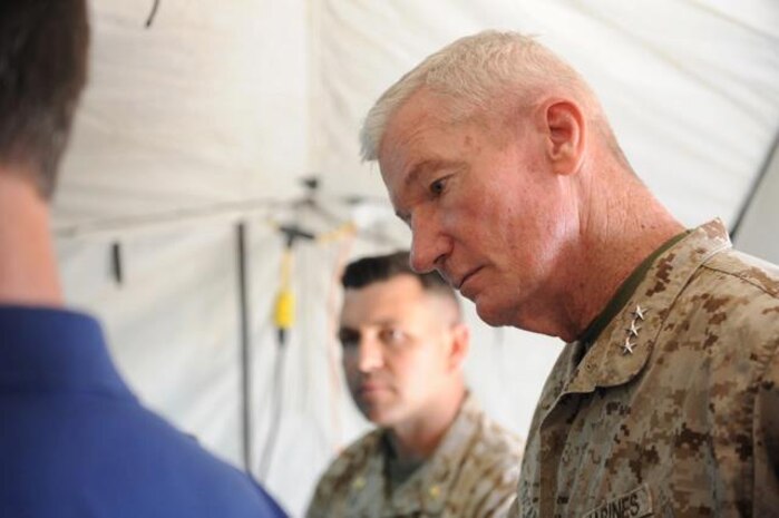 Lieutenant General John A Toolan Jr., Commanding General, I Marine Expeditionary Force listens as the USMC Metering and Monitoring System (M&M) is explained during ExFOB 2013 at MCAGCC Twentynine Palms, Calif. The current M&M prototype is designed to allow Marines to meter, monitor, record and display electrical, fuel, and environmental data. The system is intended to enable Marines to manage energy use more efficiently and effectively