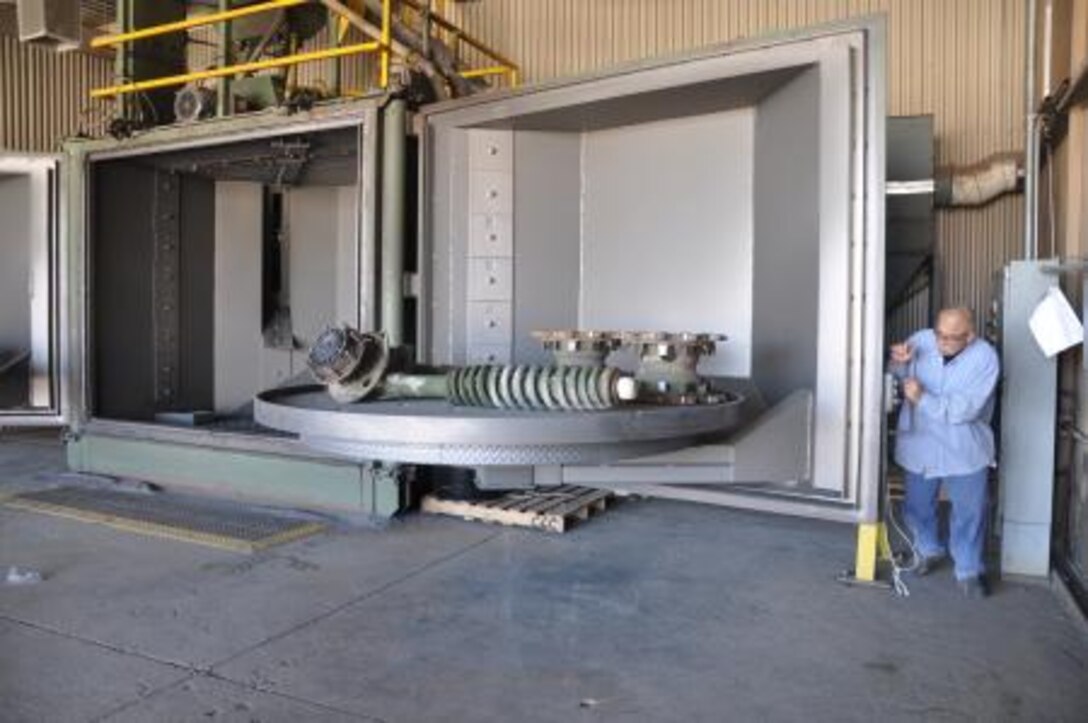 Phil Vargas, a sandblaster on Product Plant Barstow, Marine Depot Maintenance Command, shuts the door of the rotary blaster, May 24. The rotary blaster is an automated machine that is used to blast multiple parts at one time without supervision.


