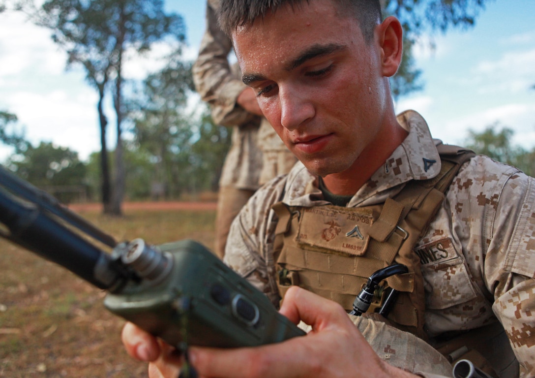 Lance Cpl. Luke Martin, 1st Platoon, Lima Company, 3rd Battalion, 3rd Marine Regiment, Marine Rotational Force - Darwin, calls for fire over the radio at the first station during a squad competition, here, May 23. MRF-D Marines ran approximately 4.5 miles, stopping only to complete different training exercises at four locations.