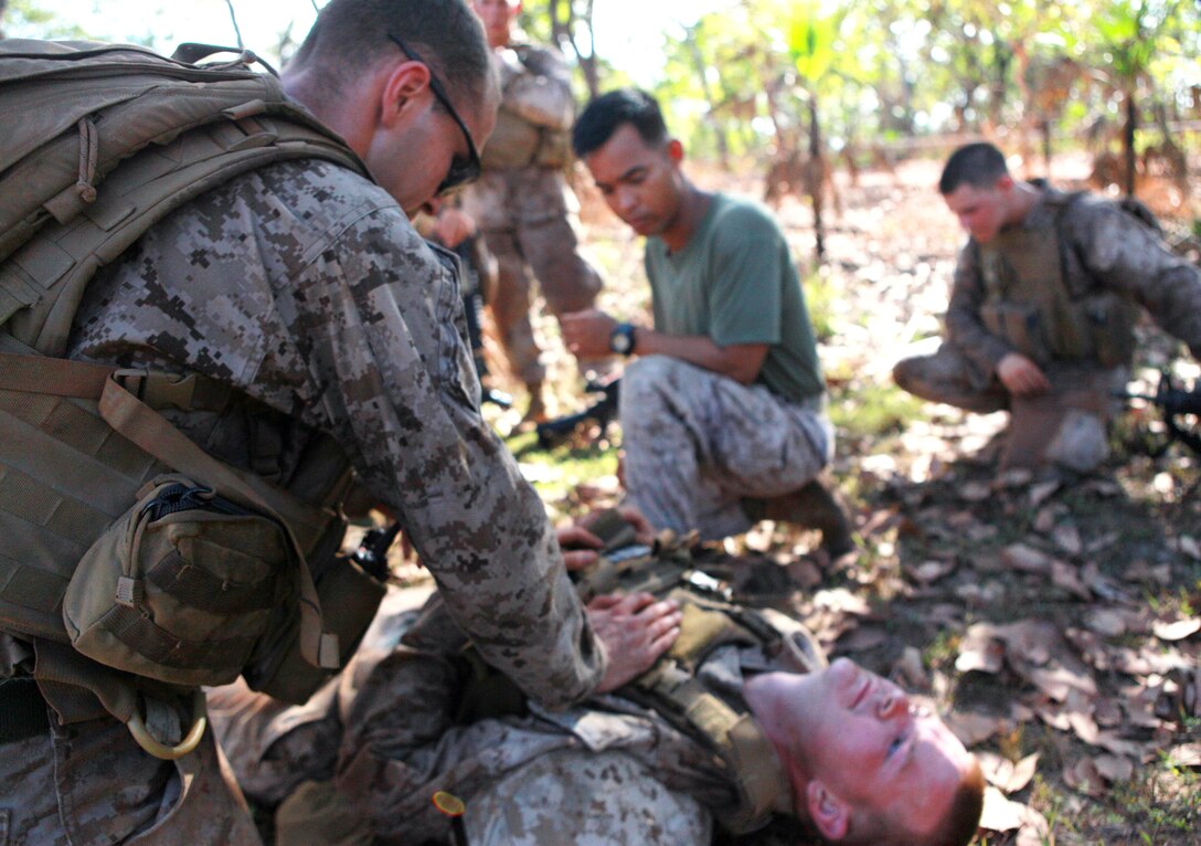 A Marine with Lima Company, 3rd Battalion, 3rd Marine Regiment, Marine Rotational Force - Darwin, treats a simulated casualty at the third station during a squad competition, here, May 23. MRF-D Marines ran approximately 4.5 miles, stopping only to complete different training exercises at four locations.