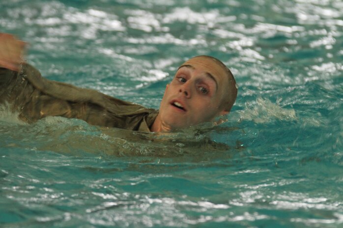 A recruit of Company B, 1st Recruit Training Battalion, swims the 25-meter portion of water survival basic at the swim tank aboard Marine Corps Recruit Depot San Diego June 4. Recruits are required to swim 25 meters in both the deep and shallow end of the pool while wearing full combat utility uniform and boots.