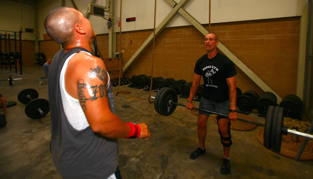 Gunnery Sgt. Jonathan Ferguson, right, the Corporal's Course director aboard Marine Corps Air Station Miramar, Calif., and a Dayton, Ohio, native, performs a dead lift as Sgt. Vincent Song, left, Corporal's Course instructor and a Chantilly, Va., native, catches his breath during a physical training session aboard MCAS Miramar, June 5. As a Marine, Ferguson takes physical training very seriously because of the need to be ready, should he be called to deploy.