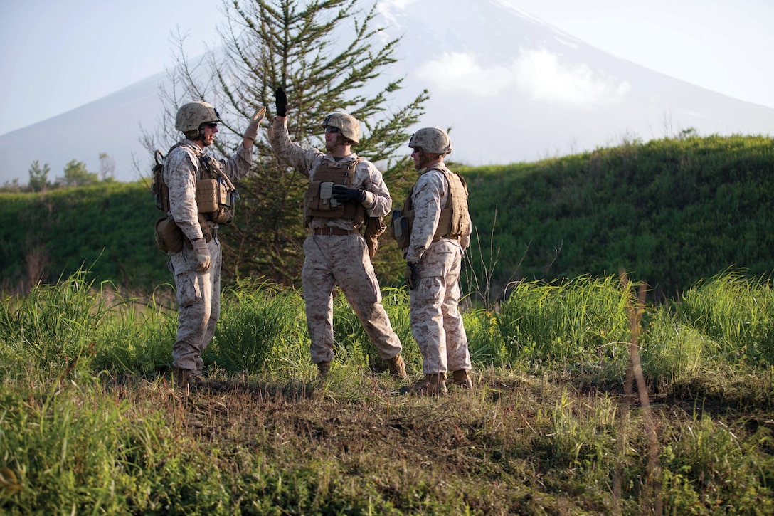 Sgt. Zach G. Gayden, left, and Sgt. Scott A. Howard celebrate their success after a training evolution June 3 at the North Training Area at Combined Arms Training Center Camp Fuji. The CAAT is comprised of numerous military occupational specialties to include machine gunners, riflemen and anti-tank misslemen.