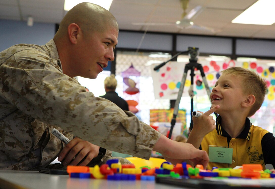 Sgt. Eli Cuaresma, embark chief, Forward Coordination Element, Marine Rotational Force - Darwin, practices spelling words with Mikey, a student at Moulden Park Primary School, here, May 15. MRF-D Marines volunteer at three local schools every week to support the community.