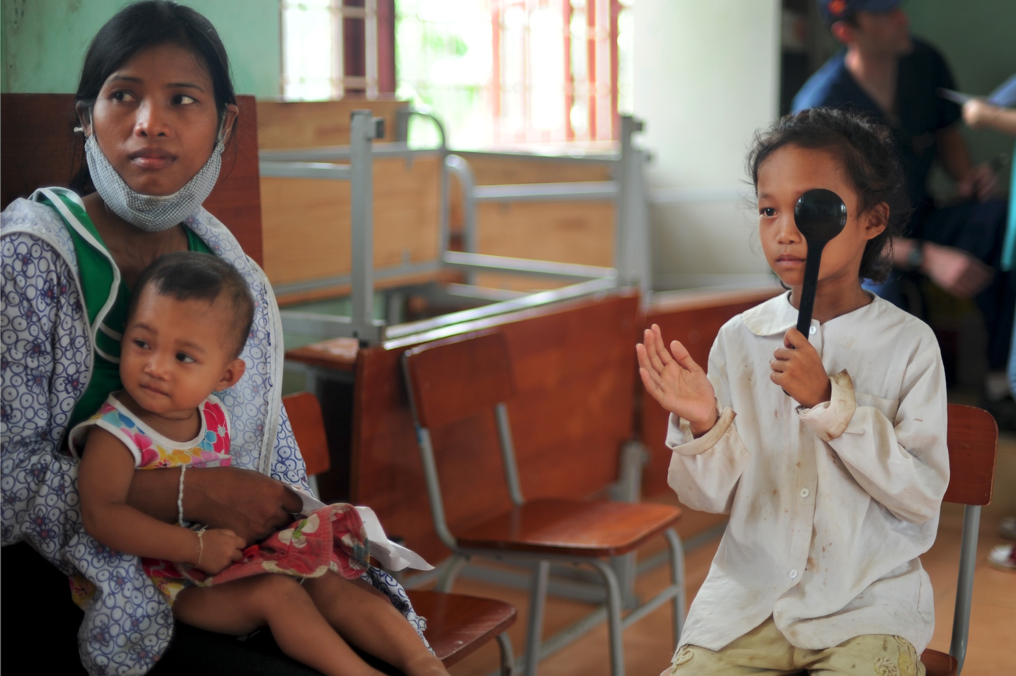 A little girl from the local community of Dong Hoi, Quang Binh Province, Vietnam reads an E Chart to properly measure her visual acuity during Operation Pacific Angel 2013 in Dong Hoi, Quang Binh Province, Vietnam, June 10, 2013. The Health Services Outreach program accommodates approximately 500 patients every day during the humanitarian mission. Operation PACANGEL is a joint and combined humanitarian assistance exercise held in various countries several times a year and includes medical, dental, optometry, engineering programs and a variety of subject-matter expert exchanges. (U.S. Air Force photo by Staff Sgt. Sara Csurilla)