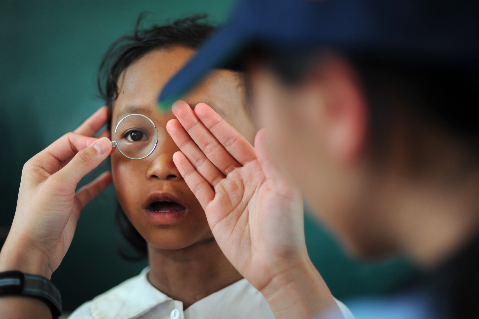 A patient looks through a lens to determine what prescription she needs for eyeglasses during Operation Pacific Angel 2013 in Dong Hoi, Quang Binh Province, Vietnam, June 10, 2013. Thousands of people have benefited from PACANGEL operations that have taken place in the Asia-Pacific over the course of six years. Operation PACANGEL is a joint and combined humanitarian assistance exercise held in various countries several times a year and includes medical, dental, optometry, engineering programs and of variety of subject-matter expert exchanges. (U.S. Air Force photo by Staff Sgt. Sara Csurilla)