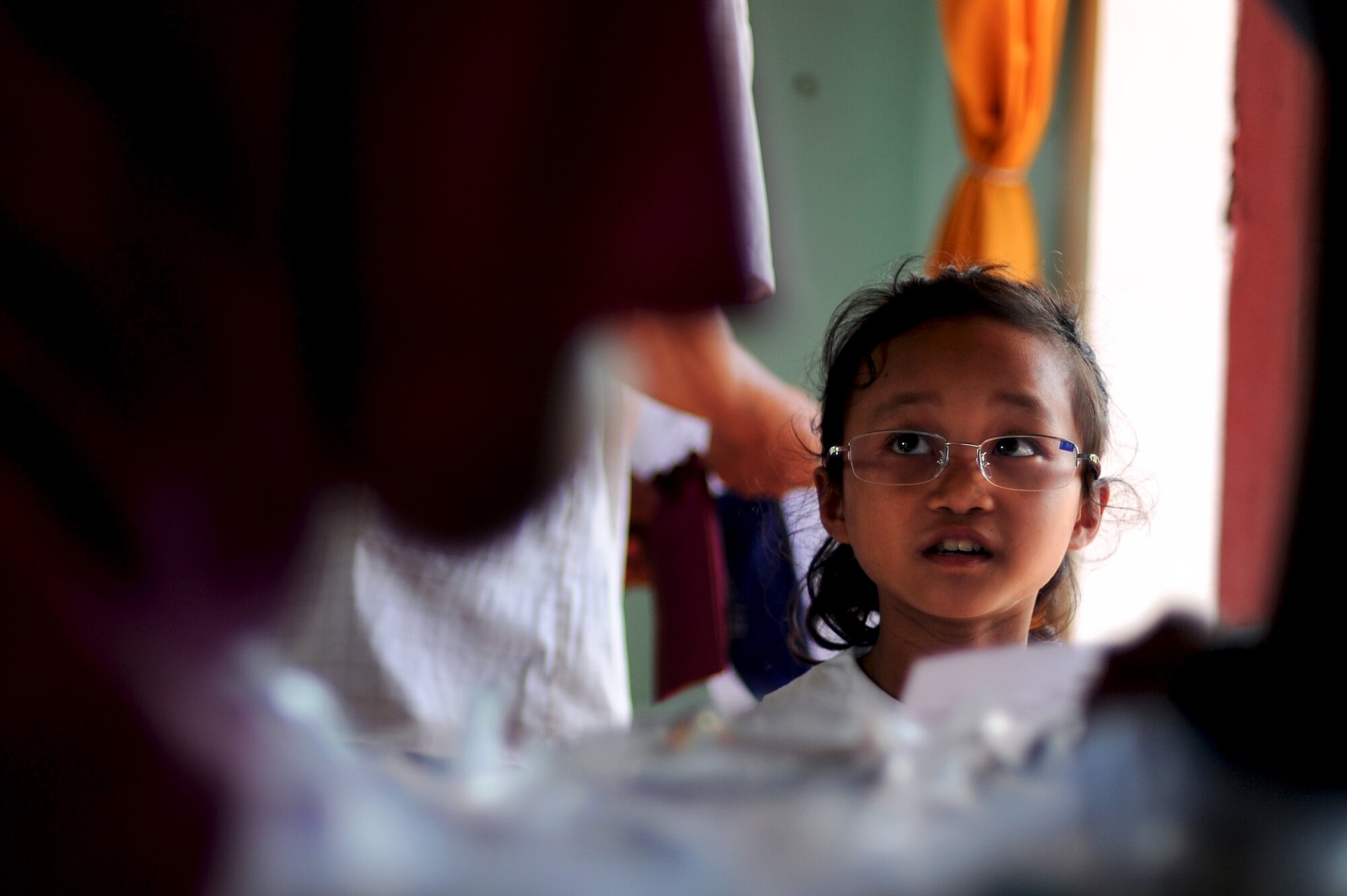 A Vietnamese child looks through her new glasses for the first time after eye specialists from the U.S. military and Vietnam People's Armed Forces examined her during Operation Pacific Angel 2013-3 in Dong Hoi, Quang Binh Province, Vietnam, June 10, 2013. The little girl, along with hundreds  of others, received glasses as part of the Health Services Outreach program during the week-long humanitarian mission. Operation PACANGEL is a joint and combined humanitarian assistance exercise held in various countries several times a year and includes medical, dental, optometry, engineering programs and a variety of subject-matter expert exchanges. (U.S. Air Force photo by Staff Sgt. Sara Csurilla)
