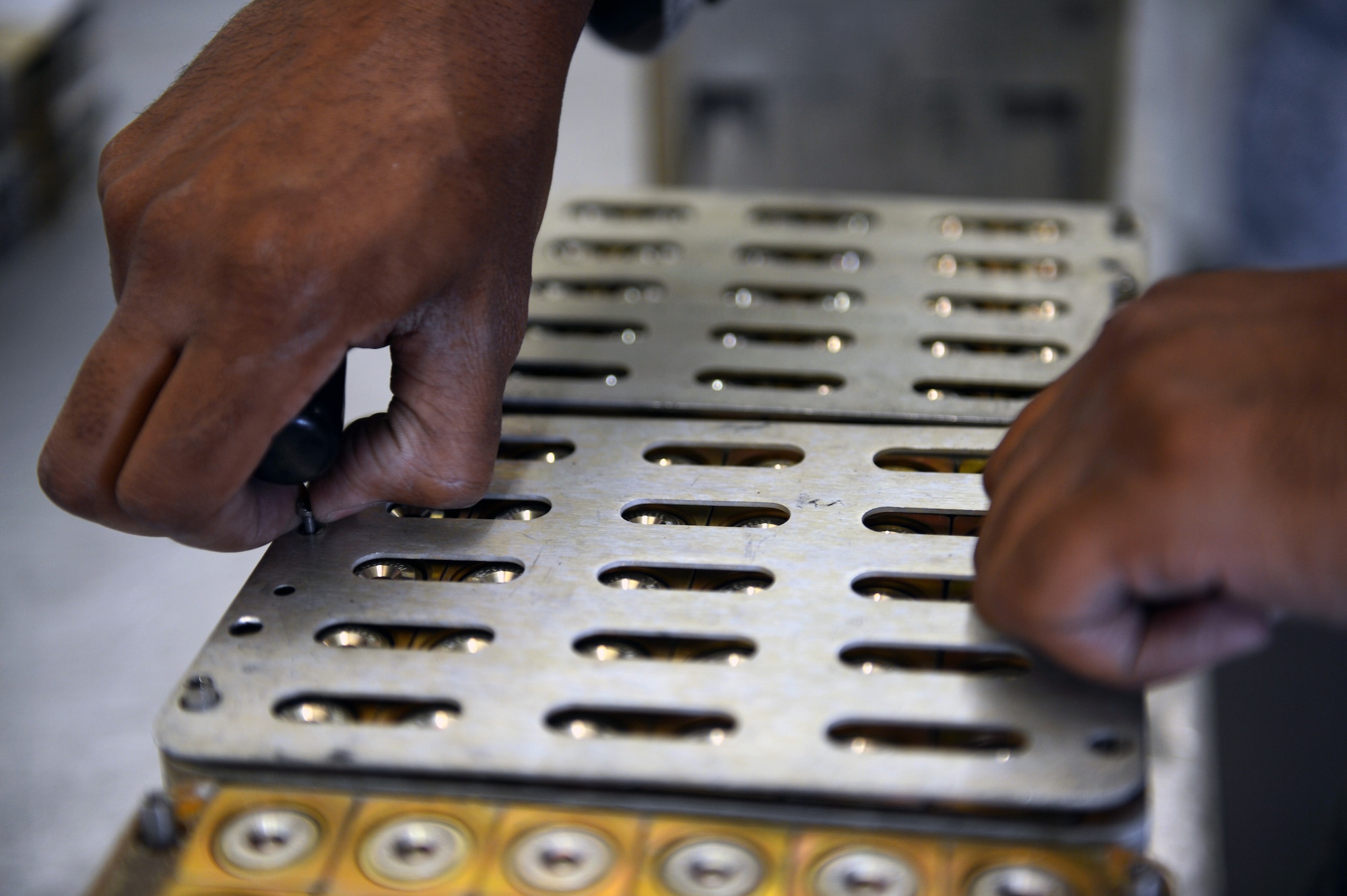Staff Sgt. Robert White, 62nd Maintenance Squadron munitions crew chief, removes a cover plate from a flare canister prior to inspection, June 10, 2013 at Joint Base Lewis-McChord, Wash. When handling flares, munitions Airmen have to be properly grounded to avoid creating static electricity that could cause flares to ignite. (U.S. Air Force photo/Airman 1st Class Jacob Jimenez)