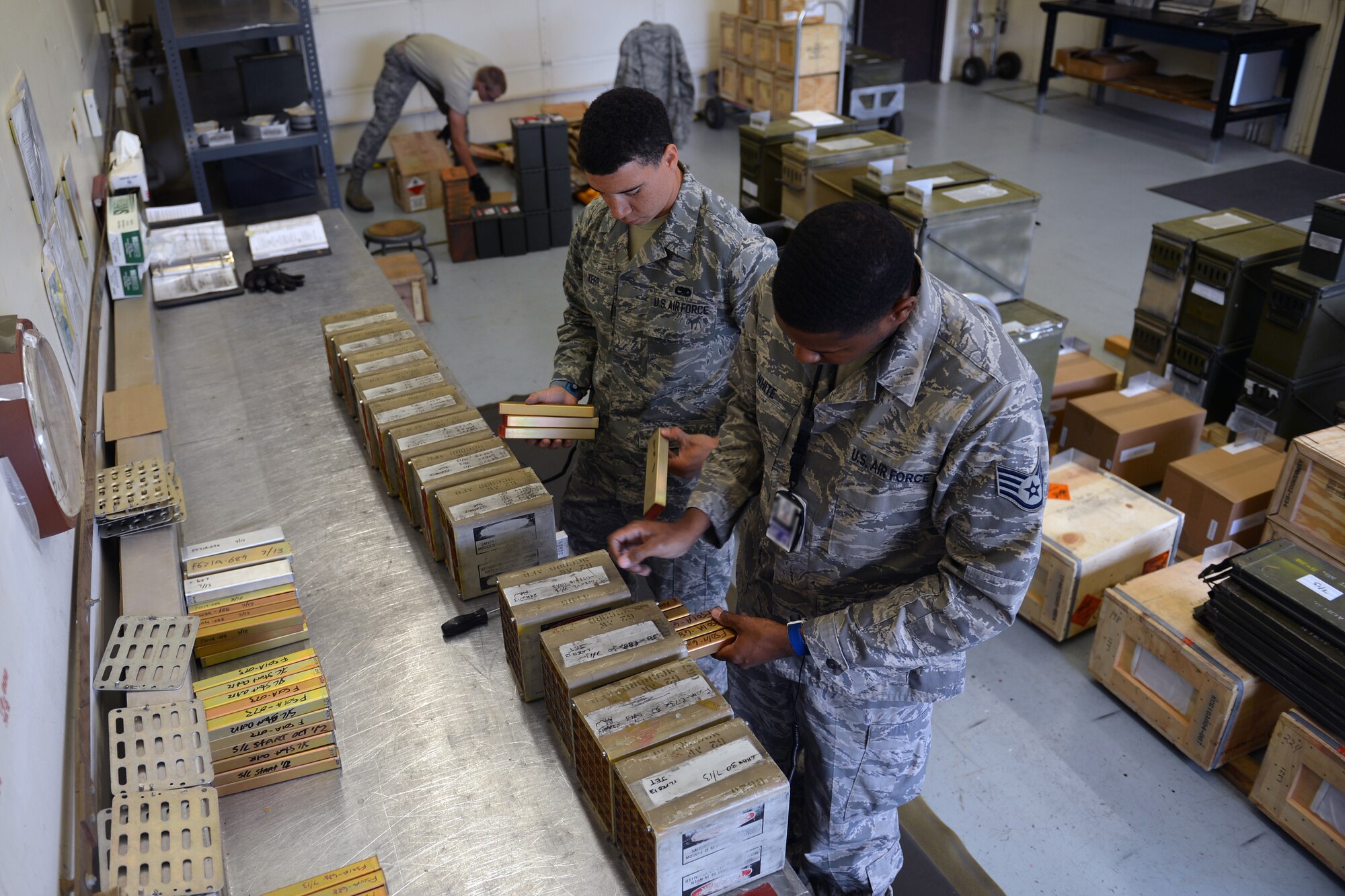 Airman 1st Class Dewayne Kerr (left), 62nd Maintenance Squadron munitions crewmember, and Staff Sgt. Robert White (right), 62nd MXS munitions crew chief, unpack and inspect flare expiration dates, June 10, 2013 at Joint Base Lewis-McChord, Wash. Flares have a service life of one year before they are decommissioned for training purposes only. (U.S. Air Force photo/Airman 1st Class Jacob Jimenez)