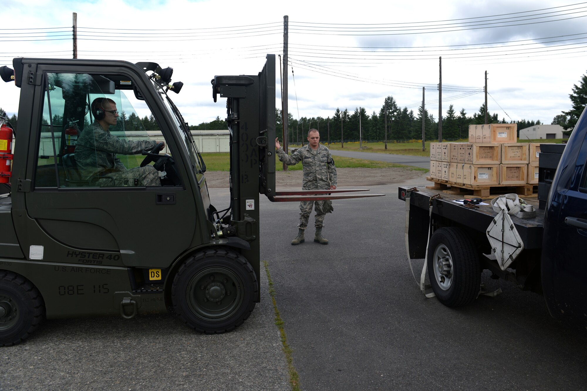 Staff Sgt. Tyson Meendering, 62nd Maintenance Squadron munitions storage crew chief, directs Airman 1st Class Forest Fender, 62nd MXS munitions crewmember, as he prepares to unload a pallet of small arms munitions from a truck, June 10, 2013 at Joint Base Lewis-McChord, Wash. The 62nd MXS munitions flight provides munitions maintenance, inspection, storage, shipping and accountability for more than 1,700 munitions valued at more than $20 million. (U.S. Air Force photo/Airman 1st Class Jacob Jimenez) 