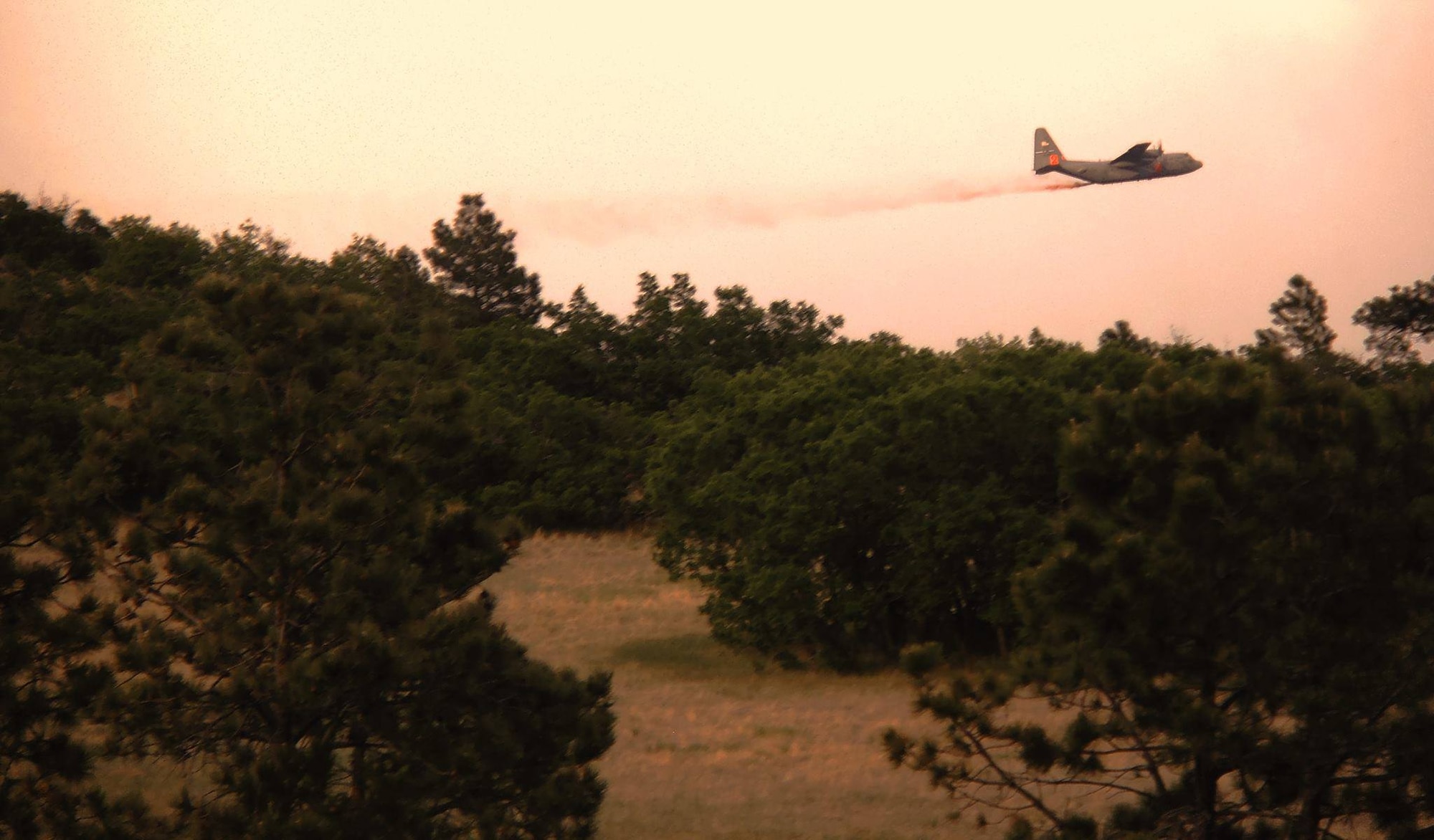 A Modular Airborne Fire Fighting System, or "MAFFS"-equipped C-130 lays down a line of fire retardant June 12 in northern El Paso County, Colo. The fire retardant is used to help contain wildland fires, assisting ground crews as they work to stop the fire's growth. Manned by Airmen of the 302nd Airlift Wing, both the aircraft and members were activated to support wildland firefighting efforts through a request from the National Interagency Fire Center in Boise, Idaho. (Courtesy photo/Travis Leland)