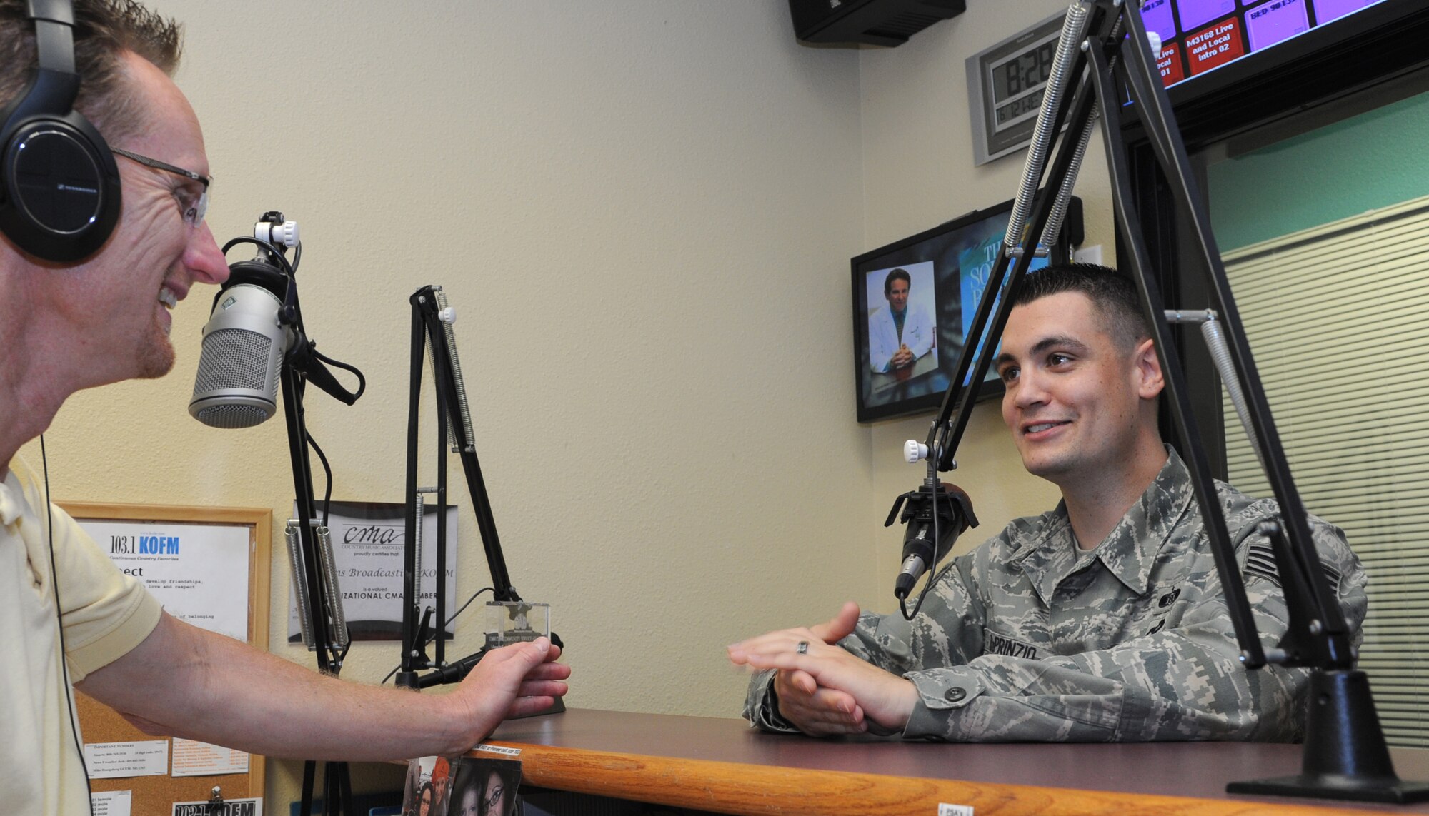 Staff Sgt. Travis DePrinzio, right, explains his job to Alan Clepper, the on-air host of the morning show at KOFM, a country music radio station in Enid, Okla., during the weekly “Warrior of the Week” segment. DePrinzio is the NCO in charge of plans and operations with the 71st Logistics Readiness Squadron at Vance Air Force Base, Okla. Clepper is also a former Honorary Commander with the 3rd Flying Training Squadron at Vance. (U.S. Air Force photo/ Senior Airman Frank Casciotta)