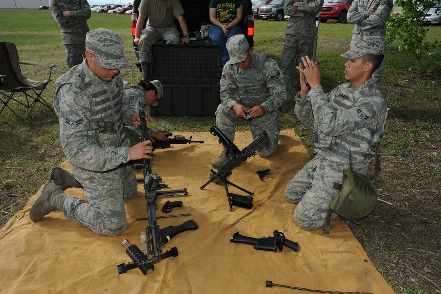 Members of team 19 assemble M-249, M-240, and M-4 weapons at station 25, box of guns. From left to right are Airman 1st Class Charles Sena; Senior Airman Mary Tarasiewicz; Senior Airman Anthony Trujillo; and Airman 1st Class Darias Faaita, all 741st Missile Security Forces Squadron members. They assembled the weapons with a total time of five minutes and 54 seconds. (U.S. Air Force photo/Senior Airman Katrina Heikkinen)