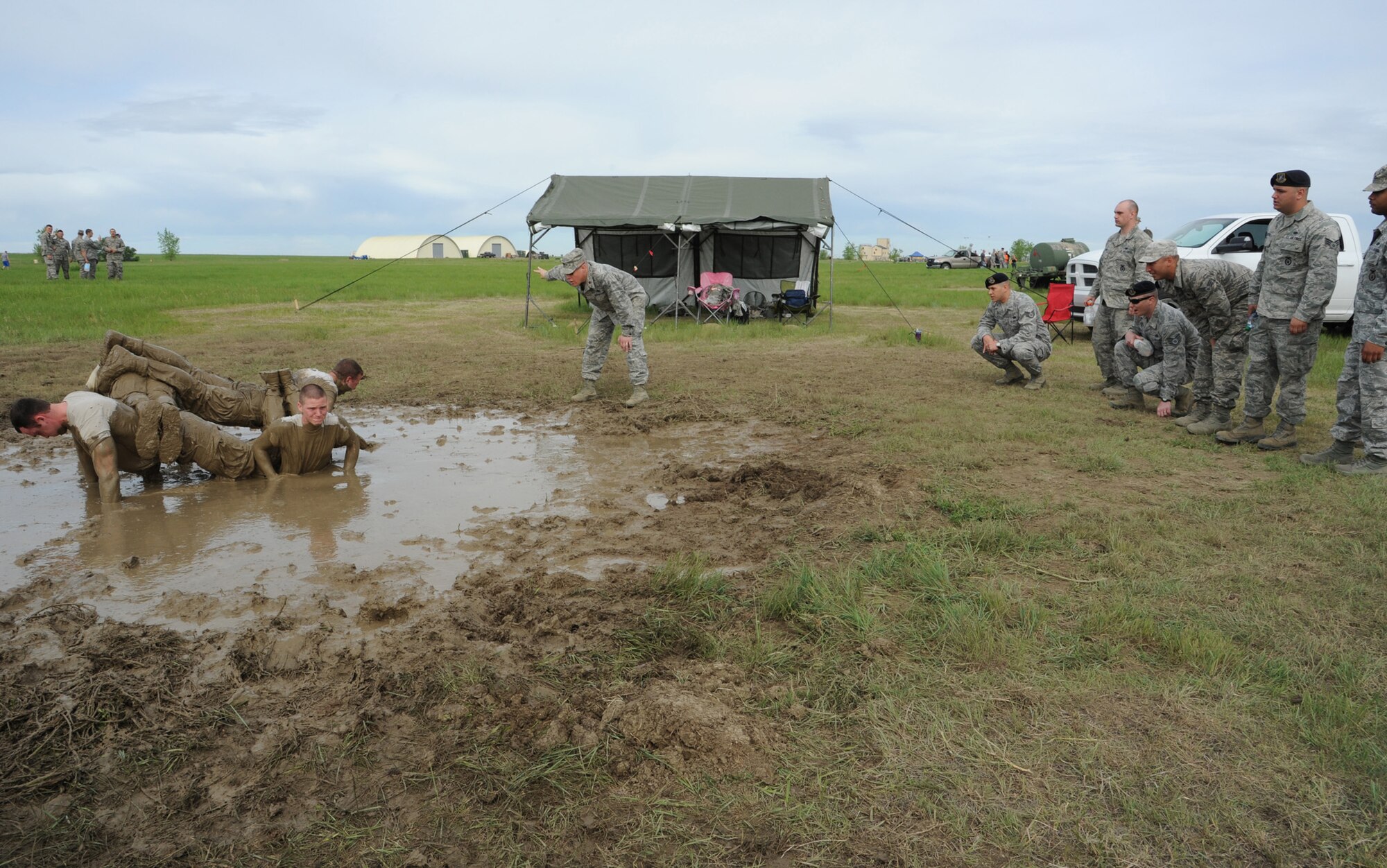Members of team 14 push themselves at the team pain station during the 2nd Annual Aces Cop Combat Challenge on June 7. Maj. Brian Copper, 341st Security Support Squadron commander, center, encouraged them to complete more push-ups. (U.S. Air Force photo/Senior Airman Katrina Heikkinen)