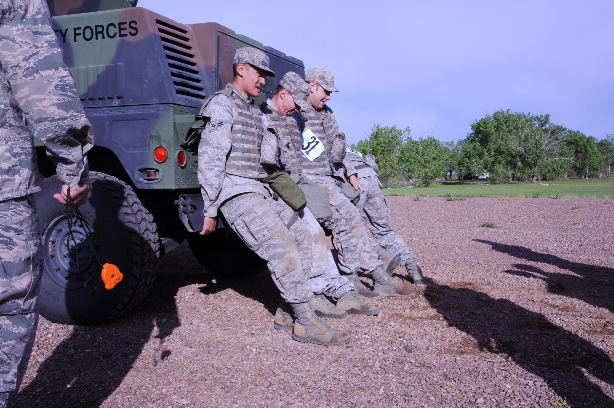 Team 8 gets behind a vehicle at the Humvee push station during the 2nd Annual Aces Cop Combat Challenge on June 7. From left to right are Airman 1st Class David Maedonochi, 741st Missile Security Forces Squadron mobile fire team member; Staff Sgt. Kellin Woods, 741st MSFS member; and Senior Airman James Ross, 741st MSFS member. Team 8 finished the Humvee push with a total time of eight minutes and 30 seconds. (U.S. Air Force photo/Senior Airman Katrina Heikkinen)