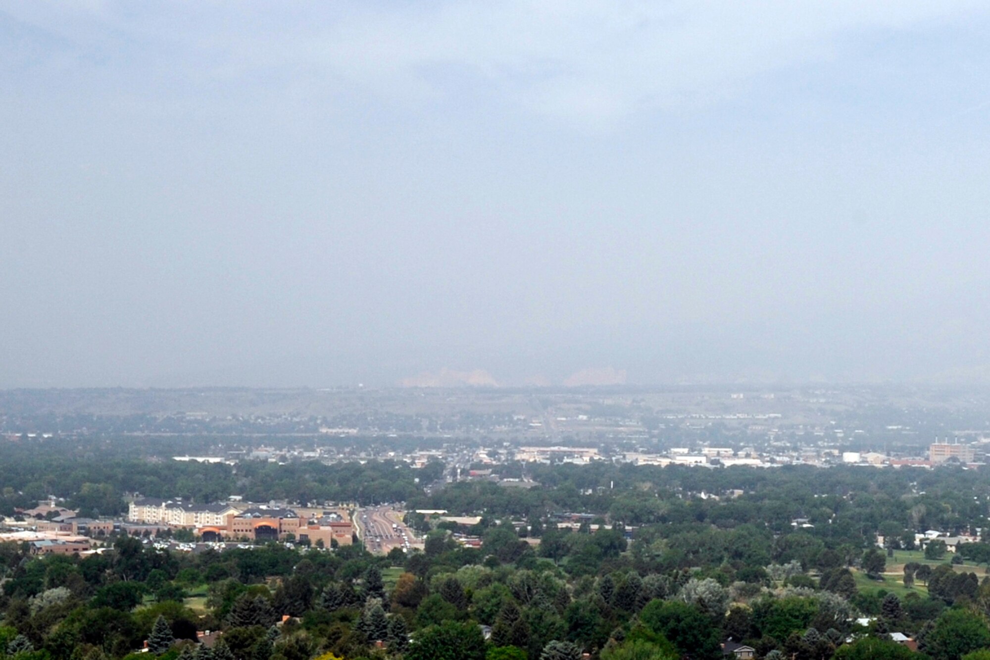 PETERSON AIR FORCE BASE, Colo. – A smoky haze generated by the Black Forest Fire masks the Garden of the Gods and Pikes Peak in this image taken from Palmer Park June 12. The wildfire began June 11 causing widespread evacuations throughout the affected region. The 21st Space Wing is providing firefighters as well as shelter for displaced DOD ID card holders.  (U.S. Air Force photo/Rob Bussard)