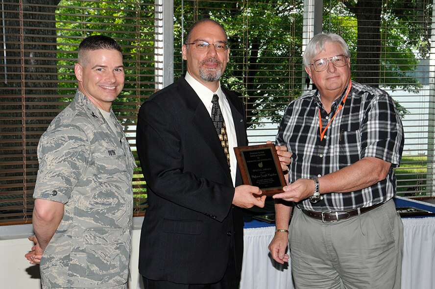 Professor Joe Majdalani (center) of UTSI receives an AIAA Special Award for outstanding graduate student mentorship from nominator Roy Schulz (right) along with AEDC Commander Col. Raymond Toth. (Photo by Rick Goodfriend)