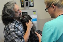 David Allen holds his dog, Buster, as Stephanie Geren, 902nd Forces Support  Squadron  veterinary technician  prepares to draw a blood sample during an examination at the Joint Base San Antonio-Randolph Veterinary Clinic June 12. (U.S. Air Force photo by A1C Alexandria E. Slade/ Released)