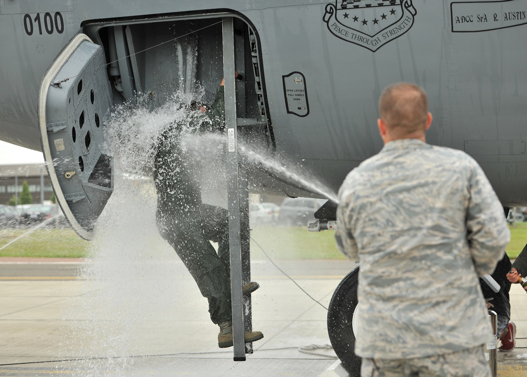 Col. Kyle Voigt, 100th Air Refueling Wing vice commander, sprays Col. Christopher Kulas, 100th ARW commander, with water as he exits a KC-135 Stratanker June 12, 2013, on RAF Mildenhall, England.  Kulas’ family and other members of Team Mildenhall took turns dousing Kulas with water as part of fini flight traditions commemorating his time as base commander. (U.S. Air Force photo by Staff Sgt. Jerilyn Quintanilla/Released)  