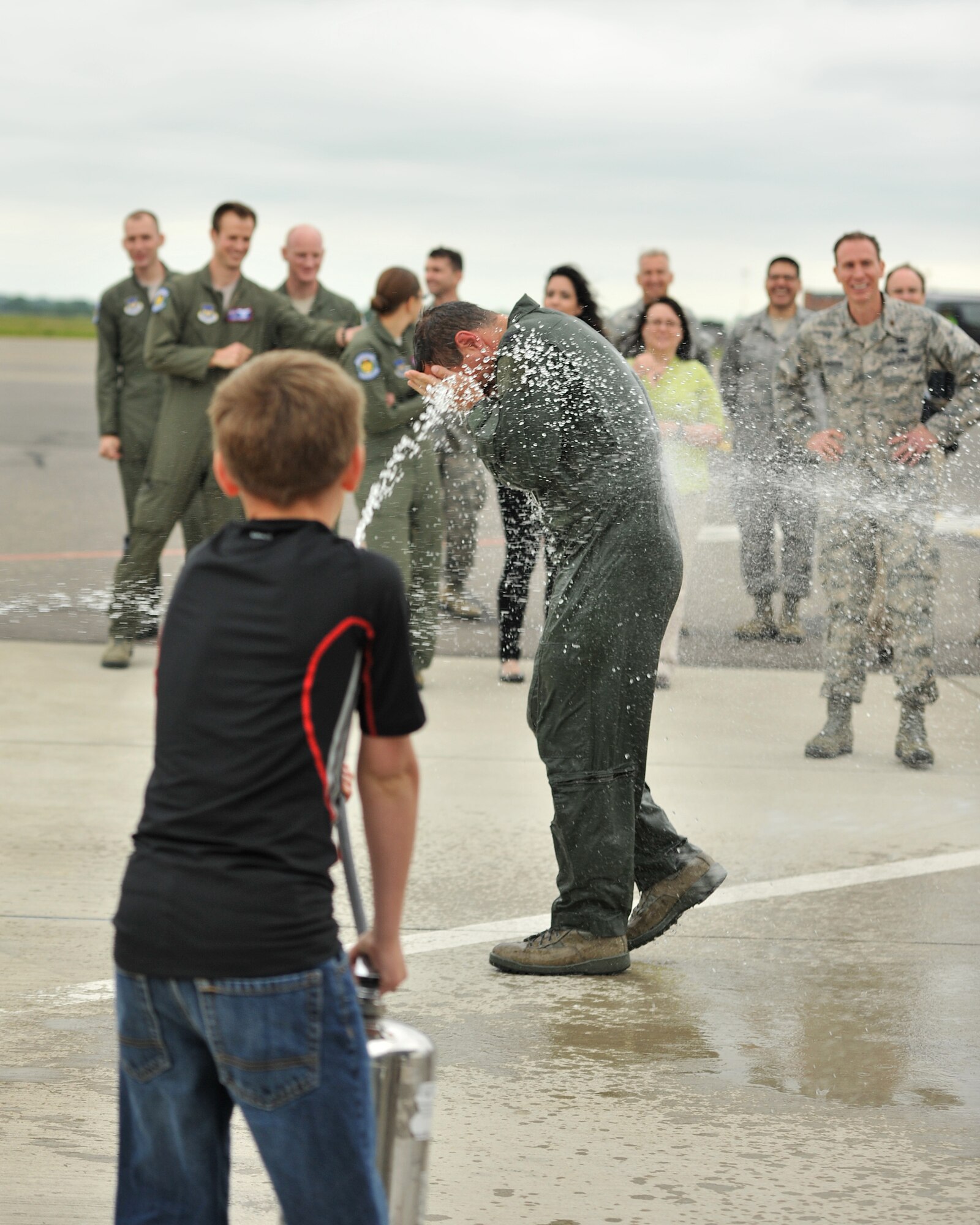 Col. Christopher Kulas, 100th Air Refueling Wing commander, is sprayed with water by his son, Samuel Kulas, 10, following his fini flight June 12, 2013, on RAF Mildenhall, England. This flight marked Kulas’ last flight as 100th ARW commander. (U.S. Air Force photo by Staff Sgt. Jerilyn Quintanilla/Released)