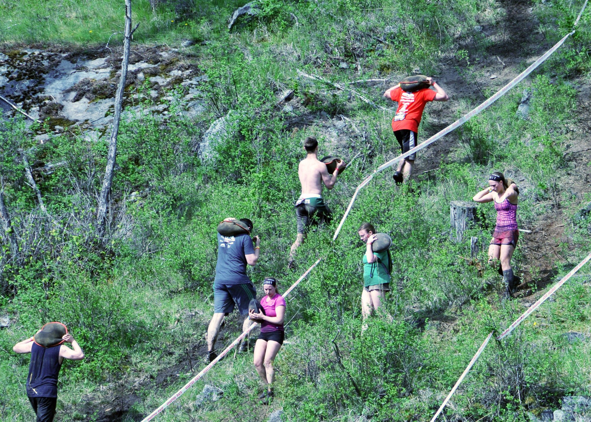 Race participants carry 60 pound bags of sand up and down a hillside during the 2013 Spartan Sprint held near Bigfork, Mont. May 11.  (U.S. Air Force photo/Tech. Sgt. Brett McCloney)