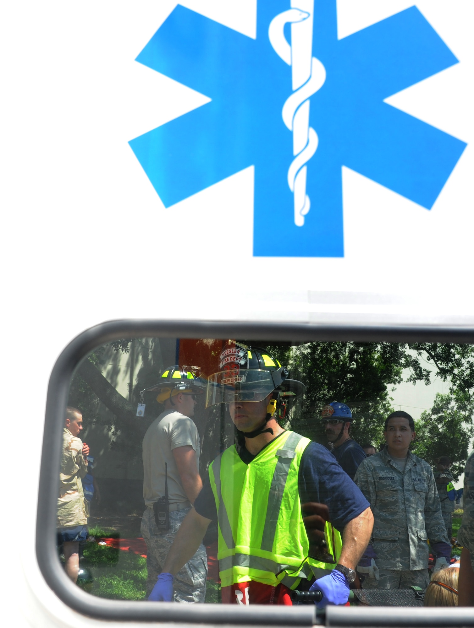 Jason Sanders, Keesler firefighter, assists with carrying a litter to the back of an ambulance to be transported to the Keesler Medical Center during Keesler's active shooter exercise, June 12, 2013, at Garrard Hall, Keesler Air Force Base, Miss.  During the two-day exercise, an Air Force couple simulated opening fire, killing three people and injuring 41.  The exercise tested the base's ability to respond to and recover from a mass casualty event.  (U.S. Air Force photo by Kemberly Groue)