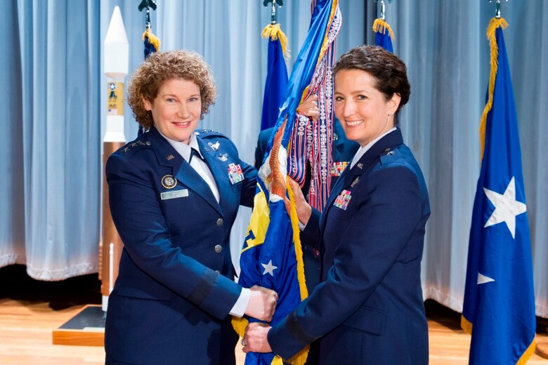 Lt. Gen. Susan Helms, left, commander, 14th Air Force, presents the 45th Space Wing Guidon to Brig. Gen. Nina Armagno, who assumed duties as the 45th Space Wing commander Wednesday morning in the Base Theater. Brigadier General Armagno is the first person ever to command both the 30th Space Wing Hawks at Vandenberg and the 45th Space Wing Sharks at Team Patrick-Cape," said Lt. Gen. Helms. "She will do an outstanding job here," she added. (Photo by Matthew Jurgens)