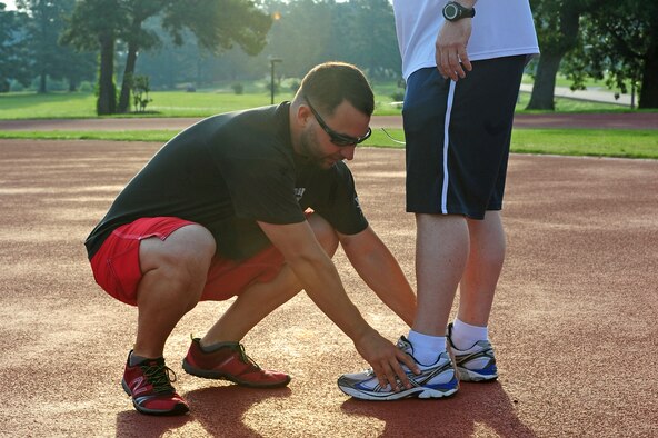 Joe Gonzalez, 4th Aerospace Medicine Squadron health and wellness center physiologist, checks for wear and tear on shoes worn by U.S. Air Force Master Sgt. Dave Sutton, 916th Aircraft Maintenance Squadron avionics section chief, during a running fundamentals class at Seymour Johnson Air Force Base, N.C., June 12, 2013. The next running fundamentals class will be held June 19, 2013 at 7 a.m. at the quarter-mile track. (U.S. Air Force photo by Airman 1st Class John Nieves Camacho/Released)